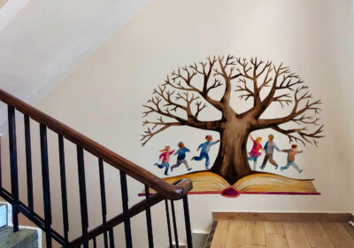 A mural of a tree on the stairs wall.